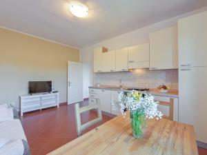 a kitchen with a vase of flowers on a table at Apartment Bartolina by Interhome in Castiglione della Pescaia