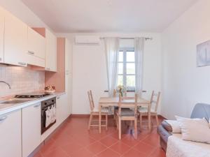 a kitchen and dining room with a table and a couch at Apartment Bartolina by Interhome in Castiglione della Pescaia
