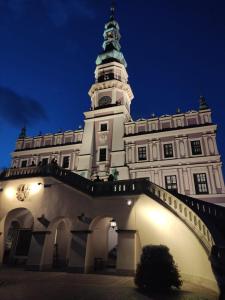 a building with a clock tower at night at Studio Żdanowska Zamość in Zamość