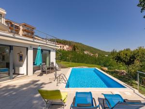 a villa with a swimming pool and chairs at Villa Anna by Interhome in Opatija