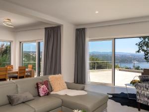 a living room with a couch and large windows at Villa Anna by Interhome in Opatija