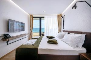 a bedroom with a bed with a view of the ocean at Olive Villas Beach Hotel in Sozopol