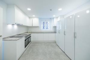 a white kitchen with white cabinets and a window at Residencia Universitaria Trinitarios in Valencia +48 photos