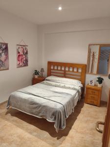 Un dormitorio con una cama y un espejo en la pared. en Apartamento en Primera Línea de Playa y Muy Céntrico, en Miramar