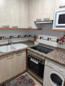 Una pequeña cocina con fregadero y estufa. en Apartamento en Primera Línea de Playa y Muy Céntrico, en Miramar