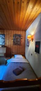 a bedroom with a large bed with a wooden ceiling at BnB Claudy et Elizabeth Michellod-Dutheil in Le Châble