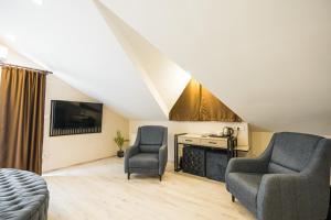 a attic living room with two chairs and a television at Monezza Maltepe Rezidans in Istanbul