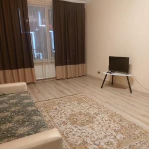 a living room with a couch and a laptop on a table at Жк Metropole 2х комнатная in Almaty