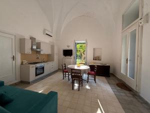 a kitchen and dining room with a table and chairs at Residenza Storica PARCO LANOCE in Poggiardo