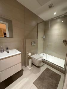 Un baño con inodoro, lavabo y ducha. en London Apartment West One, en Londres