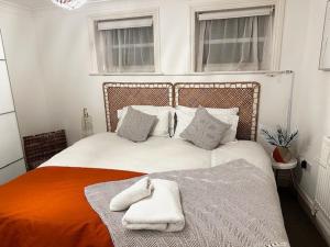 een slaapkamer met een bed met handdoeken erop bij Pier Reflections sea front apartment Long and short stays Groups and Contractors welcome in Eastbourne
