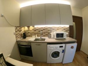 a kitchen with a sink and a washing machine at Salt Lake Studio in Pomorie +25 photos