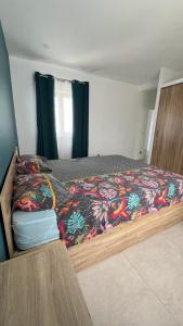 a bedroom with a bed with a colorful bedspread at Villa les vues D'Albion in Albion