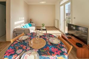 a living room with a dining table and a television at Havre familial cosy avec terrasse & lumière in Toulon