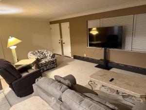 a living room with a couch and a flat screen tv at The Gather Grove in Toledo