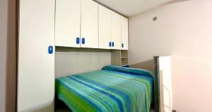 a small room with a bed and white cabinets at Sweet home Pozzuoli in Pozzuoli