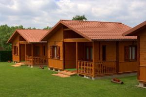 a row of wooden cottages in a yard at Camping LLuçanès in Olost