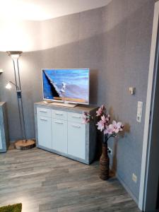een woonkamer met een tv en een vaas met bloemen bij Ferienwohnung Helmers Gemütlich wie zuhause in Braunlage