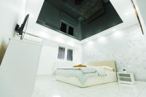 a bedroom with a bed in a white room at Archi's Apartament in Galaţi