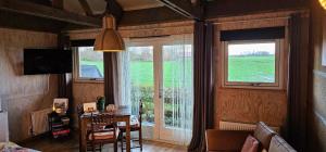 a living room with a table and two windows at B&B ZusenZomer in Oostwoud