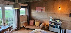 a living room with a chair and a table at B&B ZusenZomer in Oostwoud