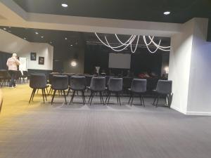 a group of chairs in a room with a stage at Domaine de Kerlann 688 in Pont-Aven +25 photos