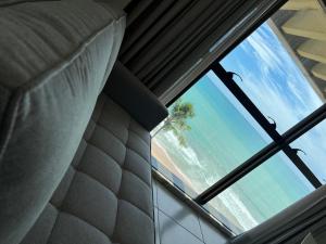 a view of the beach from a bedroom window at Refúgio do Mar 703 - Condomínio Edifício Ritz Suítes Home Service in Maceió