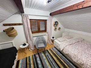 a small bedroom with a bed and a chair at Vacation house SMEKI in Lokošin Dol