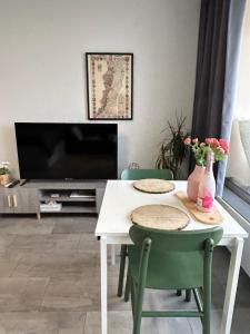 a living room with a table with two chairs and a tv at Le Panorama - GÎTES MARCK in Turckheim