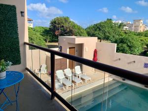 a balcony with chairs and a table and water at Mar y Chelo Luxury Aparments in Isla Mujeres