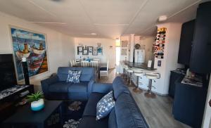 a living room with a blue couch and a kitchen at Corona Del Mar 23 in Uvongo Beach