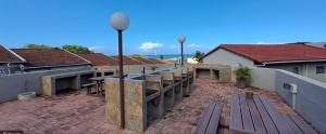 a balcony with a row of benches and street lights at Corona Del Mar 23 in Uvongo Beach