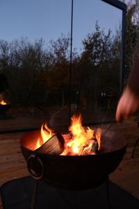 a person is cooking food over a fire at Mirror Houses Pound Farm - Meadow OOD in Saxmundham