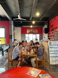 un gruppo di persone seduti a un tavolo in un ristorante di Rock Backpackers Central Hostel a Vang Vieng