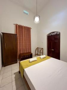 a bedroom with a large bed and a cabinet at Villa Bianca in Kegalle +12 photos