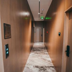 a hallway with a long corridor with wooden walls at La Onda Hotel Durres in Durrës