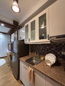 a kitchen with a sink and a refrigerator at Cozy Condo in Davao City in Davao City +4 photos
