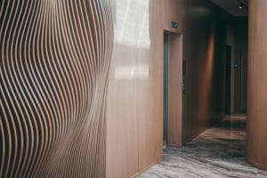 a hallway with a wooden wall and a door at La Onda Hotel Durres in Durrës