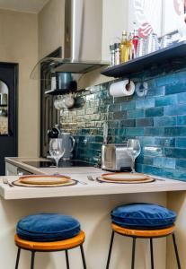 a kitchen with a counter with two blue stools at The Snug King Bed in Portsmouth