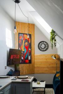 a kitchen with a painting on the wall and a clock at The Snug King Bed in Portsmouth
