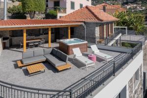 a patio with a hot tub and chairs on a building at Casa de Pedra by An Island Apart in Ribeira Brava +50 photos