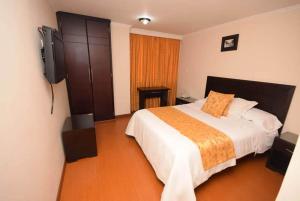 a bedroom with a bed and a flat screen tv at HOTEL ZAFIRO PLAZA in Tunja