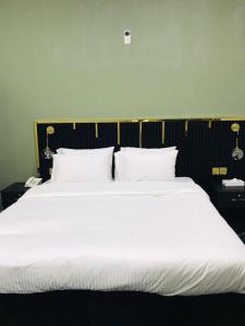 a large white bed with white sheets and pillows at Zee Hotel in Dubai +6 photos
