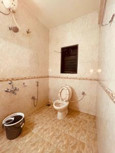 Un baño con inodoro y ventana. en Bern Hostel By Vibe Village, en Pune