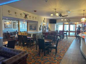 a dining room with tables and chairs in a restaurant at The Buccaneer Inn in Torquay