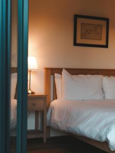 a bedroom with a bed and a table with a lamp at Forest Corner Luxury Home with Hot Tub in North Ballachulish +28 photos