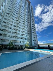a large building with a swimming pool in front of a building at Cozy Condo in Poblacion in Davao City