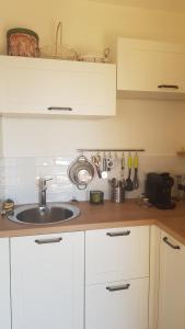 a kitchen with white cabinets and a sink at Villa Sant Andria in Biguglia +7 photos
