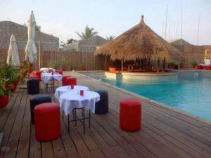 un restaurante con mesas y una piscina en Pure Plage en Lomé