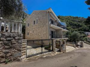 a brick house with a gate and a fence at Olive Residence Rezevici in Budva
